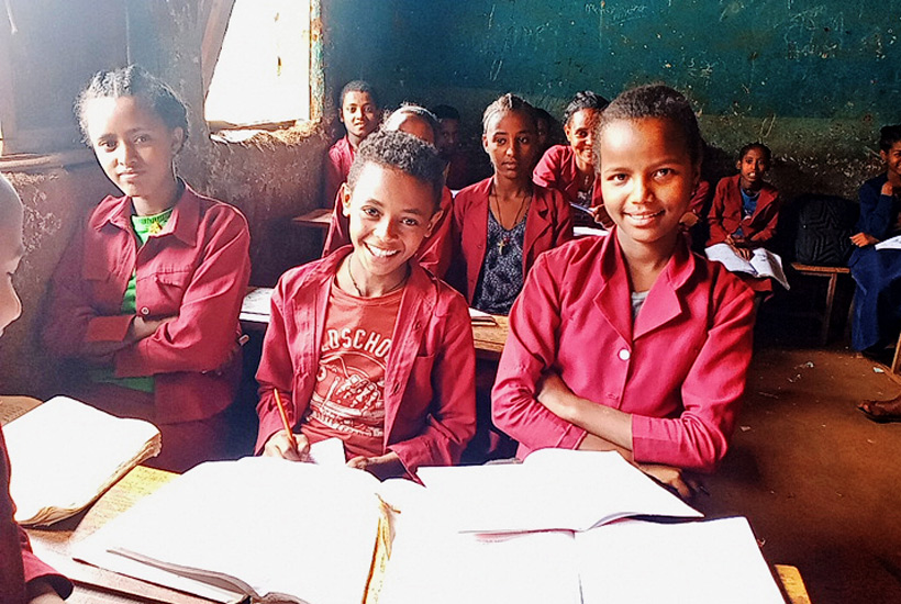 Ayana mit Schulfreundinnen im Klassenzimmer - sie hat die Kinderarbeit hinter sich gelassen