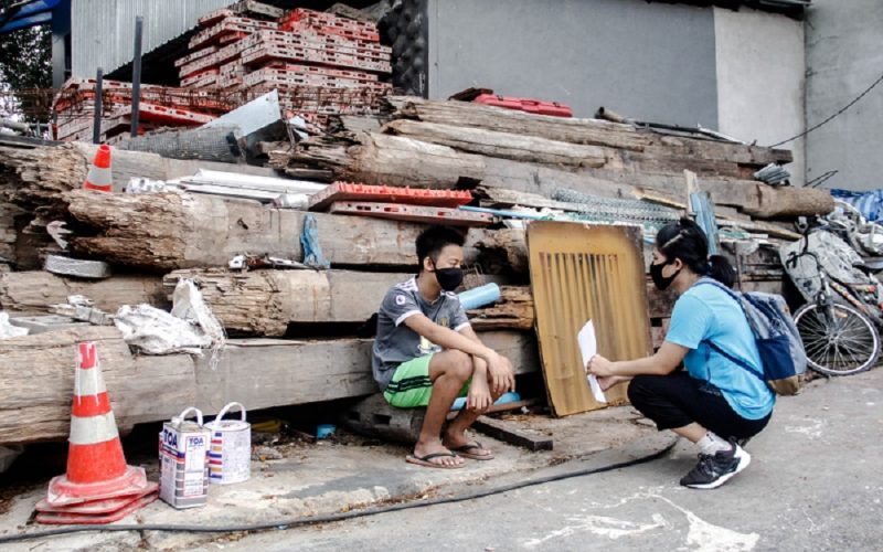 Eine Sozialarbeiterin unseres Partners BDF spricht mit einem Jugendlichen auf einer Baustelle in Thailand über die Auswirkungen der Corona Krise