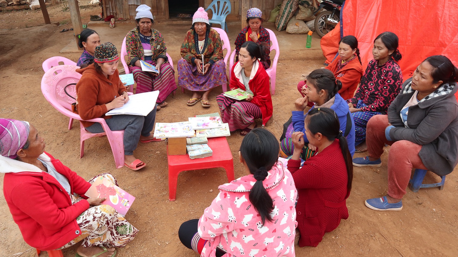 Frauen in Myanmar sitzen im Kreis und sammeln Geld für einen gemeinsamen Fonds