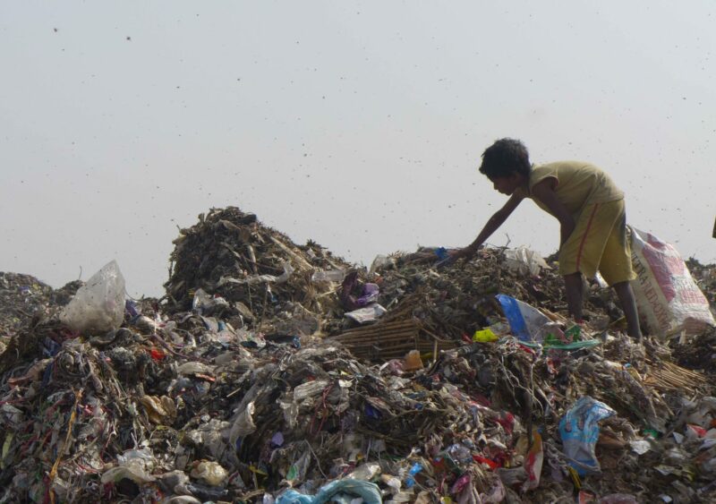 Ein Kind arbeitet auf einer Müllhalde in Delhi.