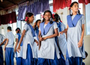 Drei indische Schülerinnen in blauer Schuluniform.